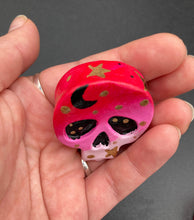 Load image into Gallery viewer, Ideal magnet design to adorn your refrigerator, lockers, workstation, toolbox, or dishwasher. This intricately detailed skull statuette is inspired by the beauty of nature, with vibrant colors ranging from red to a light pink reminiscent of a summer sky at dusk. A black moon and gold stars were added to provide a unified aesthetic. H 1 1/2” x W 1 1/2” x D 3/4”