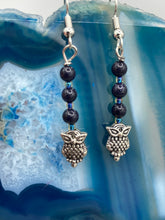 Load image into Gallery viewer, Showcasing shimmery purple goldstone beads, these classy silver-plated owl charm earrings make a statement. Measurements: 1 3/16” in length