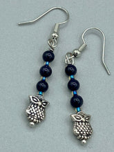 Load image into Gallery viewer, Showcasing shimmery purple goldstone beads, these classy silver-plated owl charm earrings make a statement. Measurements: 1 3/16” in length