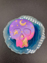 Load image into Gallery viewer, Ideal magnet design to adorn your refrigerator, lockers, workstation, toolbox, or dishwasher. This unique skull statuette features intricate details and vibrant colors, inspired by the summer sky at sundown. Variations in color from purple to light pink simulate the dramatic ombre seen in a setting sun, completed with golden stars and moon silhouettes for a celestial touch. H 1 1/2” x W 1 1/2” x D 3/4”