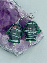 Load image into Gallery viewer, These nature-inspired glass fish earrings are the perfect addition to your boho look. Featuring a delightful dark green hue, the large puffy fish will bring a hippie vibe to your style. Measurements: 1 1/2” in length