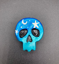 Load image into Gallery viewer, Cute and spooky magnet design to adorn your refrigerator, lockers, workstation, toolbox, or dishwasher. This hand-sculpted clay skull statuette boasts stunning ombre coloration, transitioning from dark blue to light blue to recreate the breathtaking look of a starry night sky. H 1 1/2” x W 1 1/2” x D 3/4”