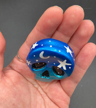 Load image into Gallery viewer, Cute and spooky magnet design to adorn your refrigerator, lockers, workstation, toolbox, or dishwasher. This hand-sculpted clay skull statuette boasts stunning ombre coloration, transitioning from dark blue to light blue to recreate the breathtaking look of a starry night sky. H 1 1/2” x W 1 1/2” x D 3/4”