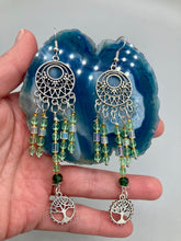 Load image into Gallery viewer, Be mesmerized by these large cascade style earrings, featuring five delicate strands of light green, iridescent and gold-tone beads with a tree of life charm for an eye-catching effect. Perfect for whimsical, nature-inspired looks, these earrings will liven up any outfit. Measurements: 3 3/4” in length