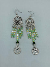 Load image into Gallery viewer, Be mesmerized by these large cascade style earrings, featuring five delicate strands of light green, iridescent and gold-tone beads with a tree of life charm for an eye-catching effect. Perfect for whimsical, nature-inspired looks, these earrings will liven up any outfit. Measurements: 3 3/4” in length