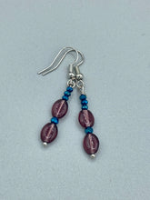 Load image into Gallery viewer, These dainty earrings feature a combination of light purple and dark blue glass beading for a sophisticated, versatile look. Perfect for a chic aesthetic, these earrings can easily complement any outfit.  Measurements: 1 3/8” in length