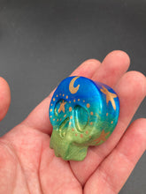 Load image into Gallery viewer, Inspired by nature, this skull statuette is full of vibrant colors and intricate details. The ombre colors from red, to light pink was inspired by the summer sky at sundown that I see all too often. I really wanted to capture those beautiful colors and added metallic gold moon and stars silhouettes to tie it all together.