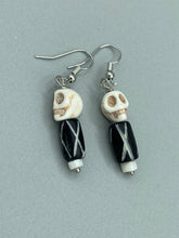 Load image into Gallery viewer, This set of earrings features a mini howlite skull bead with a wood carved black and white bead. Perfect for any goth, emo, witchy, or Day of the Dead outfit, it adds a unique touch to any ensemble. Measurements: 1 1/2 ” in length