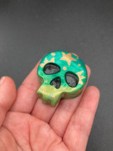 Load image into Gallery viewer, Ideal magnet design to adorn your refrigerator, lockers, workstation, toolbox, or dishwasher. Featuring intricate details and vibrant colors, this hand-painted skull statuette is inspired by nature. Its warm metallic green and gold hues recall the gorgeous tansy beetle, and the addition of moon and stars silhouettes creates a complete celestial motif.  H 1 1/2” x W 1 1/2” x D 3/4”