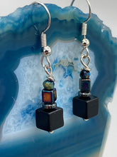 Load image into Gallery viewer, This unique set of earrings features large, square-shaped black obsidian beads accented by small, square hematite beads with flat disk details. It offers a versatile style perfect for any occasion. Measurements: 1” in length
