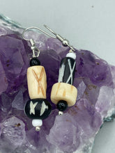 Load image into Gallery viewer, This set of earrings is crafted from a mix of bone and wood carved beads, giving it an eye-catching, one-of-a-kind look. It's versatile enough to dress up or down, making it a great choice for any occasion. Measurements: 1 1/2 ” in length