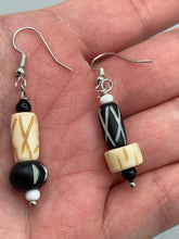 Load image into Gallery viewer, This set of earrings is crafted from a mix of bone and wood carved beads, giving it an eye-catching, one-of-a-kind look. It's versatile enough to dress up or down, making it a great choice for any occasion. Measurements: 1 1/2 ” in length