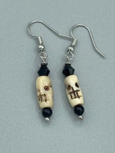 Load image into Gallery viewer, This set of mini bone skull earrings with black glass beads is an ideal addition to any gothic, emo, or witchy-inspired look. The unique day-of-the-dead aesthetic of these earrings will add a special touch to any outfit — dress them up or dress them down! Measurements: 1 1/4 ” in length