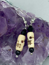 Load image into Gallery viewer, This set of mini bone skull earrings with black glass beads is an ideal addition to any gothic, emo, or witchy-inspired look. The unique day-of-the-dead aesthetic of these earrings will add a special touch to any outfit — dress them up or dress them down! Measurements: 1 1/4 ” in length