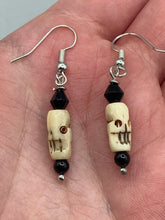 Load image into Gallery viewer, This set of mini bone skull earrings with black glass beads is an ideal addition to any gothic, emo, or witchy-inspired look. The unique day-of-the-dead aesthetic of these earrings will add a special touch to any outfit — dress them up or dress them down! Measurements: 1 1/4 ” in length