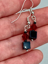 Load image into Gallery viewer, This eye-catching piece features two unconventional components: a large square-shaped black obsidian bead and a large, dark red glass bead. With the beautiful interplay of colors and shapes, these earrings are truly unique, yet at the same time, versatile enough to be paired with a range of styles. Measurements: 1” in length