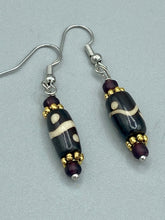 Load image into Gallery viewer, This set of earrings features a distinct wave and circle design crafted from bone and gold-tone metal, with an array of neutral colors that add versatility and a unique look to any ensemble.  Measurements: 1 1/2 ” in length