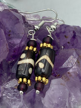 Load image into Gallery viewer, This set of earrings features a distinct wave and circle design crafted from bone and gold-tone metal, with an array of neutral colors that add versatility and a unique look to any ensemble.  Measurements: 1 1/2 ” in length