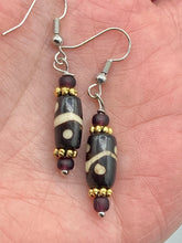 Load image into Gallery viewer, This set of earrings features a distinct wave and circle design crafted from bone and gold-tone metal, with an array of neutral colors that add versatility and a unique look to any ensemble.  Measurements: 1 1/2 ” in length