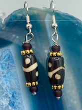 Load image into Gallery viewer, This set of earrings features a distinct wave and circle design crafted from bone and gold-tone metal, with an array of neutral colors that add versatility and a unique look to any ensemble.  Measurements: 1 1/2 ” in length