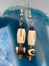 Load image into Gallery viewer, This set of earrings features a cylinder bone bead and round bone bead with eye design and a gold-tone glass bead. Neutral colors allow for versatile styling; the resulting look is sure to be unique.  Measurements: 1 1/2 ” in length