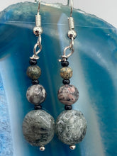 Load image into Gallery viewer, These earrings are crafted with tourmaline quartz, snowflake obsidian and black glass beads, creating a neutral cool look that is both unique and adaptable to any style. Measurements: 1 1/2” in length