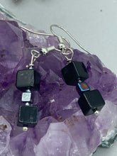 Load image into Gallery viewer, This pair of earrings features two large square-shaped black obsidian beads and small square-shaped hematite beads. With its distinct yet versatile look, this item is sure to make a statement. Measurements: 1” in length