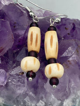 Load image into Gallery viewer, This classic set of earrings is crafted with a combination of cylindrical and round bone beads and dark burgundy glass beads. Offering subtle versatility with its neutral colors, it can easily dress up or dress down any look for a distinct, unique style.  Measurements: 1 5/8 ” in length
