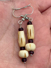 Load image into Gallery viewer, This classic set of earrings is crafted with a combination of cylindrical and round bone beads and dark burgundy glass beads. Offering subtle versatility with its neutral colors, it can easily dress up or dress down any look for a distinct, unique style.  Measurements: 1 5/8 ” in length