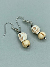 Load image into Gallery viewer, These handcrafted Mini Howlite Skull Bead and Bone Carved Bead Earrings will give any goth, emo, or witchy outfit an extra special touch. Perfect for Day of the Dead celebrations or any casual occasion, these unique earrings will make any look stand out. Measurements: 1 1/4 ” in length