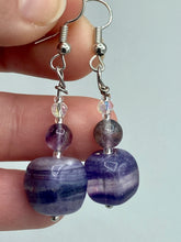 Load image into Gallery viewer, This luxurious set of earrings feature large square-shaped rainbow fluorite beads contrasted against round amethyst beads, presenting an elegant neutral yet cool-toned look. With its unique and versatile style, these earrings make a perfect addition to any wardrobe. Measurements: 1 3/8” in length