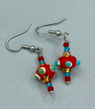 Load image into Gallery viewer, This eye-catching set of earrings features colorful, bumpy round lampworked glass beads in vivid shades of fire engine red, white, green, and orange. An iconic fiesta piñata-shaped bead completes the unique and bold design, but also reminiscent of a virus. A spectacular accessory, these earrings are sure to draw attention.  Measurements: 1 1/4” in length