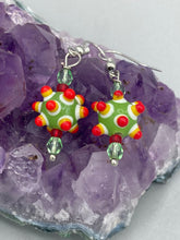 Load image into Gallery viewer, Vibrant, bumpy round lampworked glass beaded earrings in an array of colors including light green, white, yellow, dark red and bright orange. The fiesta piñata-shaped bead invokes a festive vibe, while its unique virus-shaped design promotes a bold statement. An eye-catching and unique piece of jewelry sure to turn heads. Measurements: 1 1/4” in length