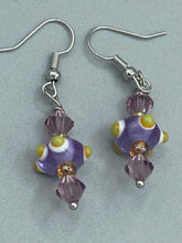 Load image into Gallery viewer, Marvel at the vivid colored bumpy round lampworked glass beads in this earring set, ranging from soft purple to yellow and white. Get creative and imagine the fiesta piñata-shaped bead as a virus for a unique, one-of-a-kind look. Crafted with care and full of personality, this jewelry will be sure to make a statement. Measurements: 1 1/4” in length