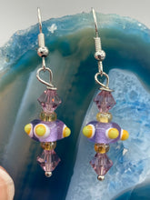 Load image into Gallery viewer, Marvel at the vivid colored bumpy round lampworked glass beads in this earring set, ranging from soft purple to yellow and white. Get creative and imagine the fiesta piñata-shaped bead as a virus for a unique, one-of-a-kind look. Crafted with care and full of personality, this jewelry will be sure to make a statement. Measurements: 1 1/4” in length