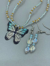 Load image into Gallery viewer, Elevate your style with these simple yet dainty beaded earrings boasting a gentle iridescent and frosty light blue hue. Perfectly versatile, they will add a refined touch to any outfit.  Measurements: 1 1/4” in length