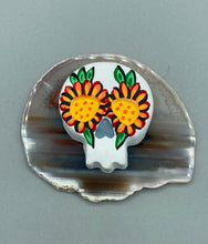 Load image into Gallery viewer, Heal emotionally and spiritually through art by honoring a loved one with a unique and beautiful Purple Spirit Piece Memorial Skull Art. Day Of The Dead Spirit Piece is an ideal addition to your ofrenda or altar that will provide a lasting tribute. These handcrafted polymer clay skull figurines are adorned with hand-painted bright orange floral designs for the eyes. H 1 1/2” x W 1 1/2” x D 3/4”