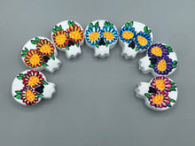 Load image into Gallery viewer, Heal emotionally and spiritually through art by honoring a loved one with a unique and beautiful Purple Spirit Piece Memorial Skull Art. Day Of The Dead Spirit Piece is an ideal addition to your ofrenda or altar that will provide a lasting tribute. These handcrafted polymer clay skull figurines are adorned with hand-painted dark floral designs for the eyes. H 1 1/2” x W 1 1/2” x D 3/4”