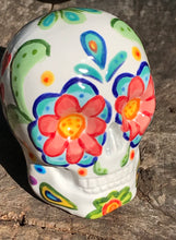 Load image into Gallery viewer, This hand-painted, mini ceramic sugar skull art piece is inspired by peacock feathers, perfect colorful artwork for Dia de Los Muertos. The intricate design captures the beauty of peacock feathers bring a unique and beautiful piece to your ofrenda and celebrate your loved ones in style. Measurements: H 2 3/4” x W 2” x D 2”