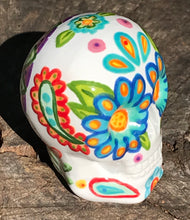 Load image into Gallery viewer, This hand-painted, mini ceramic sugar skull art piece is inspired by peacock feathers, perfect colorful artwork for Dia de Los Muertos. The intricate design captures the beauty of peacock feathers bring a unique and beautiful piece to your ofrenda and celebrate your loved ones in style. Measurements: H 2 3/4” x W 2” x D 2”