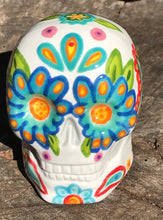 Load image into Gallery viewer, This hand-painted, mini ceramic sugar skull art piece is inspired by peacock feathers, perfect colorful artwork for Dia de Los Muertos. The intricate design captures the beauty of peacock feathers bring a unique and beautiful piece to your ofrenda and celebrate your loved ones in style. Measurements: H 2 3/4” x W 2” x D 2”