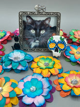 Load image into Gallery viewer, Heal emotionally and spiritually through art by honoring a loved one with a unique and beautiful Purple Spirit Piece Memorial Skull Art. Day Of The Dead Spirit Piece is an ideal addition to your ofrenda or altar that will provide a lasting tribute. These handcrafted polymer clay skull figurines are adorned with hand-painted dark floral designs for the eyes. H 1 1/2” x W 1 1/2” x D 3/4”