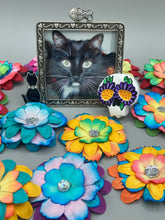 Load image into Gallery viewer, Heal emotionally and spiritually through art by honoring a loved one with a unique and beautiful Purple Spirit Piece Memorial Skull Art. Day Of The Dead Spirit Piece is an ideal addition to your ofrenda or altar that will provide a lasting tribute. These handcrafted polymer clay skull figurines are adorned with hand-painted dark purple floral designs for the eyes. H 1 1/2” x W 1 1/2” x D 3/4”