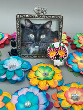 Load image into Gallery viewer, Heal emotionally and spiritually through art by honoring a loved one with a unique and beautiful Purple Spirit Piece Memorial Skull Art. Day Of The Dead Spirit Piece is an ideal addition to your ofrenda or altar that will provide a lasting tribute. These handcrafted polymer clay skull figurines are adorned with hand-painted dark floral designs for the eyes. H 1 1/2” x W 1 1/2” x D 3/4”