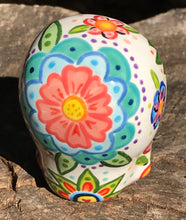 Load image into Gallery viewer, This hand-painted, mini ceramic sugar skull art piece is inspired by peacock feathers, perfect colorful artwork for Dia de Los Muertos. The intricate design captures the beauty of peacock feathers bring a unique and beautiful piece to your ofrenda and celebrate your loved ones in style. Measurements: H 2 3/4” x W 2” x D 2”