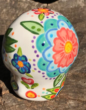 Load image into Gallery viewer, This hand-painted, mini ceramic sugar skull art piece is inspired by peacock feathers, perfect colorful artwork for Dia de Los Muertos. The intricate design captures the beauty of peacock feathers bring a unique and beautiful piece to your ofrenda and celebrate your loved ones in style. Measurements: H 2 3/4” x W 2” x D 2”