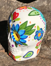 Load image into Gallery viewer, This hand-painted, mini ceramic sugar skull art piece is inspired by peacock feathers, perfect colorful artwork for Dia de Los Muertos. The intricate design captures the beauty of peacock feathers bring a unique and beautiful piece to your ofrenda and celebrate your loved ones in style. Measurements: H 2 3/4” x W 2” x D 2”