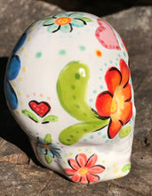 Load image into Gallery viewer, This Mini Floral Ceramic Sugar Skull pays homage to the Dia De Los Muertos tradition. Featuring a vibrant red and yellow flower inspired by a trip to the D.C. Arboretum, this piece of Day Of The Dead Skull Art is a wonderful way to honor those dearly departed. The perfect addition to any home. Measurements: H 2 3/4” x W 2” x D 2”