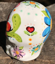 Load image into Gallery viewer, This Mini Floral Ceramic Sugar Skull pays homage to the Dia De Los Muertos tradition. Featuring a vibrant red and yellow flower inspired by a trip to the D.C. Arboretum, this piece of Day Of The Dead Skull Art is a wonderful way to honor those dearly departed. The perfect addition to any home. Measurements: H 2 3/4” x W 2” x D 2”