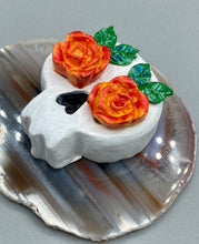 Load image into Gallery viewer, Cremation memorial art, such as Day of the Dead Spirit Pieces, provide a unique way to keep a loved one close to your heart. Handcrafted with care, each piece of artwork is specially tailored to the individual, providing a lasting reminder of those who are dearly missed. On altars and ofrendas, these pieces make a beautiful addition. Composed with meticulous attention to detail, these mini polymer clay skulls feature hand sculpted bright orange/yellow roses and leaves. H 1 1/2” x W 1 1/2” x D 3/4”